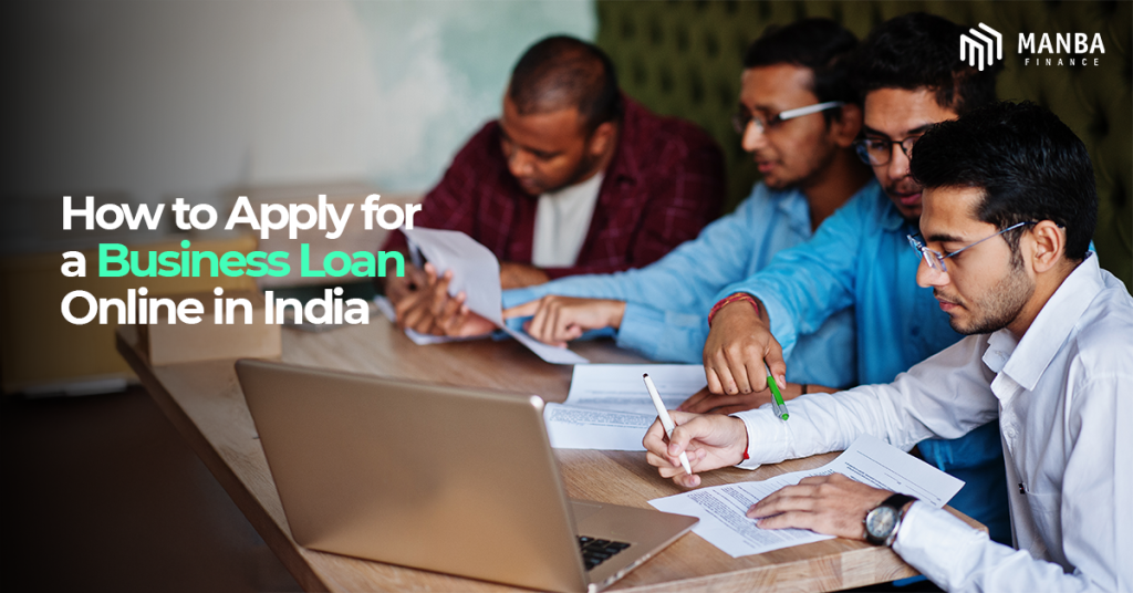 Group of professionals reviewing documents and using a laptop with text about applying for a business loan online in India by Manba Finance.